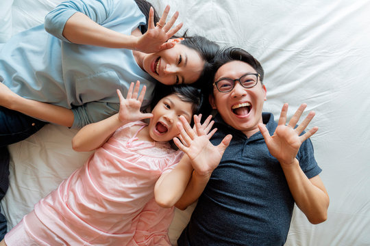 Asian Family mother father and daughter making a fun sleep play in living room home background.