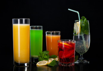 A set of cocktails of fresh fruit juices on a black background