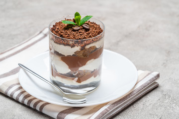 Classic tiramisu dessert in a glass on concrete background