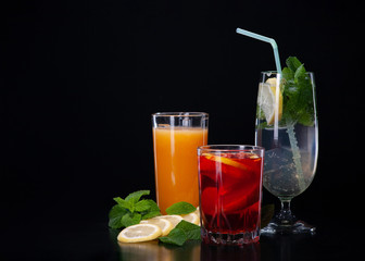 A set of cocktails of fresh fruit juices on a black background