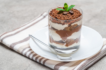 Classic tiramisu dessert in a glass on concrete background