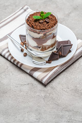 Classic tiramisu dessert in a glass on concrete background