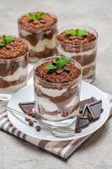 Classic tiramisu dessert in a glass on concrete background
