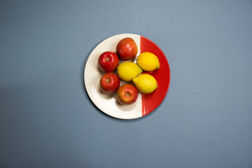 four apples and three lemons on a plate