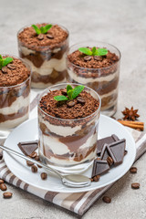 Classic tiramisu dessert in a glass on concrete background