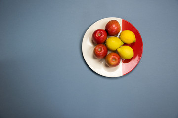 four apples and three lemons on a plate
