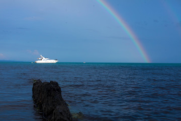 Beautiful landscape with rainbow sunset sky and super yacht on the sea