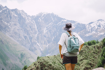Fototapeta na wymiar Young woman tourist admiring mountains in in Georgia