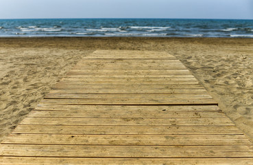 Wooden walkway on a golden sand beach 