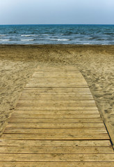 Fototapeta na wymiar Wooden walkway on a golden sand beach 