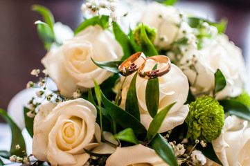 Obraz na płótnie Canvas Bouquet of roses with golden wedding rings on it