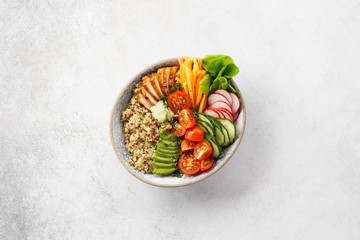 Healthy buddha bowl with chicken, quinoa and fresh vegetables.