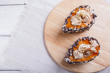 cakes with chocolate chips  and cream decorations  on wooden board on white background.