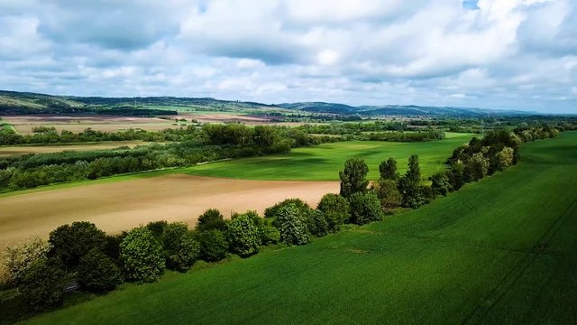 Aerial landscape shot of cloudy bright and shady view of agricultural areas hills turning over road summer zala county hungary europe