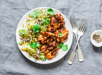 Delicious lunch - grilled chicken fillet and  dill, cilantro new potatoes salad on grey background, top view