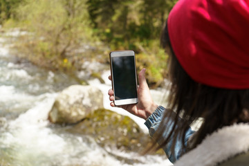 Blank screen smart phone in hand the explorer and traveler in the mountains. 