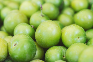 Green plums close-up. Fresh plums (cherry plums) background pattern close up, top view