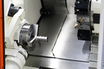 Operator machining automotive part by cnc turning machine,