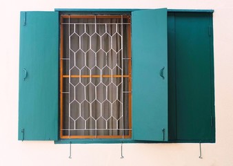 Green Wooden Window with Metal Grill on The Wall