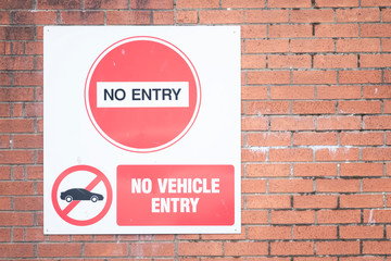 Obraz premium No vehicle entry sign on red brick wall
