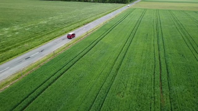 Aerial landcape shot following a claret van driving on road agricultural area windy weather zala county hungary europe