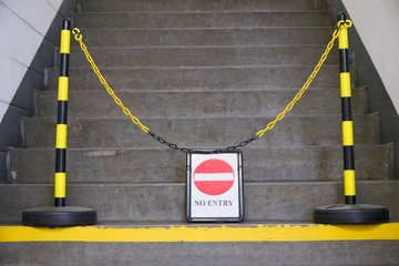 No entry sign and yellow chain in front of stair steps - obrazy, fototapety, plakaty