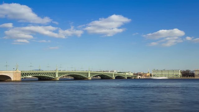 Traffic of cars by Trinity Bridge (Troitskiy Most) over the Neva river and The Palace Embankment (Palace Quay) in sunny day, St. Petersburg, Russia, timelapse