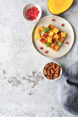 Sweet breakfast with homemade waffles, fresh mango, pomegranate and mint. Top view. Vertical photo.