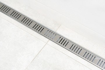 Linear shower drain system with steel grate. Drainage at bathroom