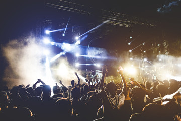 Fototapeta Young people dancing and having fun in summer festival party outdoor - Crowd with hands up celebrating concert event - Soft focus on center hand with yellow background flare - Fun and youth concept obraz