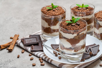 Classic tiramisu dessert in a glass on concrete background