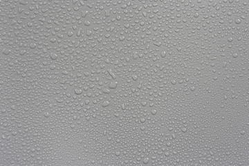 Rain on the hood, gray background car.