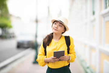 Happy tourist woman used tablet for searching the street locations