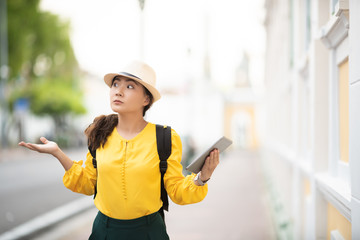 Woman traveler lost in the city used tablet for searching location