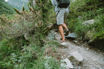 Close up shot of the man legs hiking in the mountains