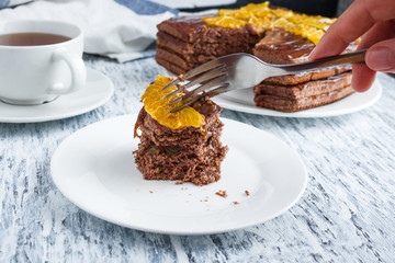woman eats chocolate cake with fork close up