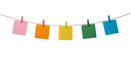 Five multicolored paper blank notes hanging on the rope with wooden clothespins isolated on white background