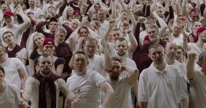 MODEL RELEASED Front view group of people fans wearing red and white clothes are outraged during a sport event. 4K UHD