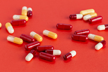 Red-white, yellow-white soluble capsules with medicine on a red background