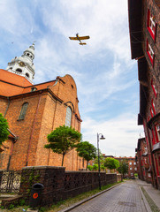 Samolot przelatuje nad kościołem w starej, górniczej dzielnicy Katowic