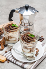Classic tiramisu dessert in a glass and coffee makeron concrete background