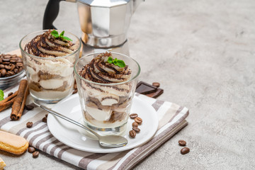 Classic tiramisu dessert in a glass and coffee makeron concrete background