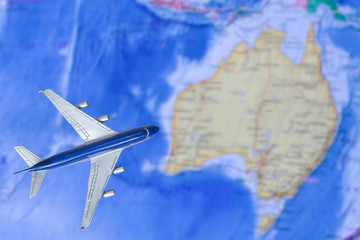 Toy plane over world map. Air trip to Australia. Travel by plane, booking tickets, flight by aircraft concept