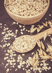 Oatmeal - a component of a healthy diet, on a dark background.