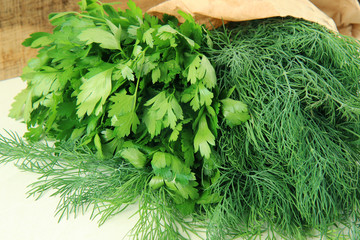 dill and parsley on wooden background