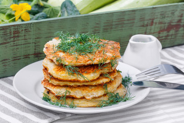 Delicious pancakes from courgettes and fresh vegetables with sour cream and dill