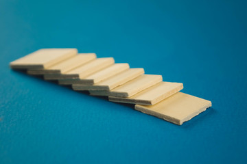 standing on top of each other small wooden blocks on a blue background