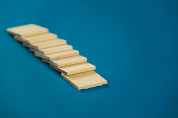 standing on top of each other small wooden blocks on a blue background