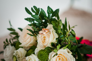 Bouquet of roses with golden wedding rings on it