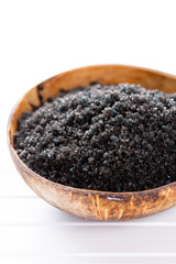 Sea salt in bowl, aroma oil in bottles, Wellness and flowers on grey textured background and flowers on vintage wooden background. Selective focus.